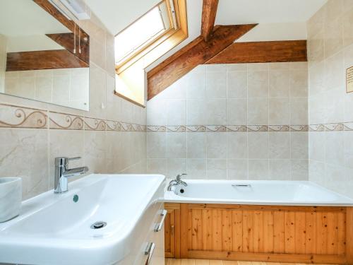 LlanegrynY Bwthyn的浴室配有盥洗盆和浴缸。