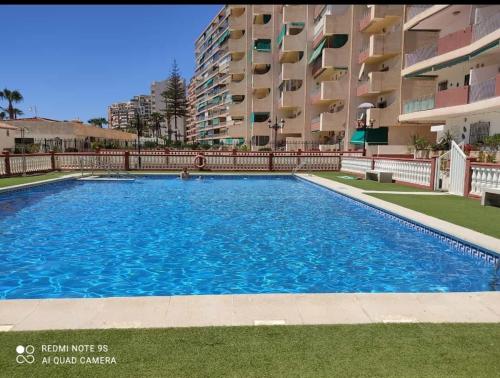 阿尔姆尼卡Apartamento reformado en primera linea de playa的大楼前的大型游泳池