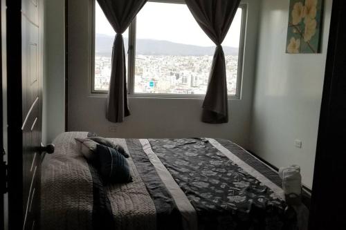 安巴托Hermosa Casa Vacacional en Ambato sector Pinllo CON UNA VISTA ÚNICA DE LA CIUDAD的一间市景卧室,配有一张床