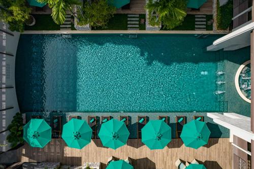 清迈Maladee Rendezvous Hotel Chiang Mai的享有带遮阳伞的游泳池的顶部景致