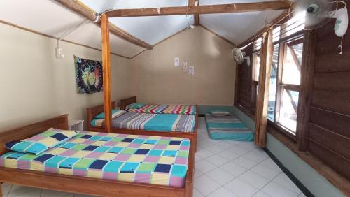 KalakHarry's Ocean House Watukarung Homestay的一间卧室设有两张床和窗户。