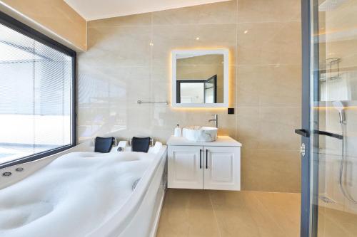 卡尔坎Villa Summery的带浴缸、水槽和镜子的浴室