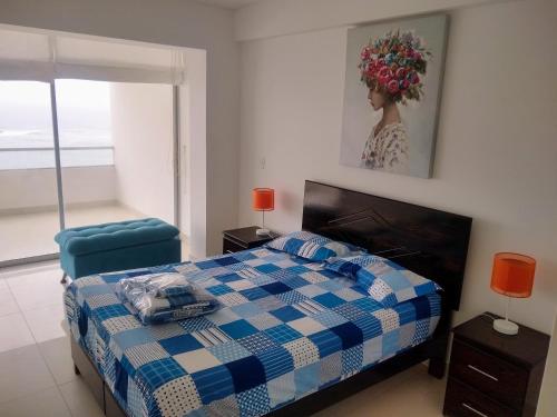 蓬塔赫尔莫萨Departamento en Punta Hermosa con Vista al Mar的卧室配有蓝色和白色的床和椅子