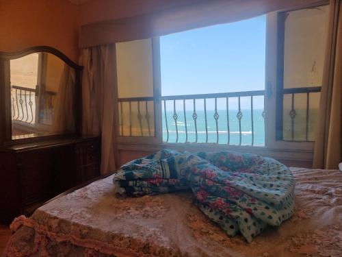 亚历山大Panoramic Sea View ZAMZM Flat miami FAMILY شقة فندقية زمزم بانورما بشاطئ ميامي - الاسكندرية صف اول مباشر علي بحر - عائلات فقط的一间卧室设有一张床和一个海景窗户