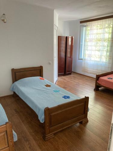 马钦加里Guest House Maxim的一间卧室配有一张床,铺有木地板