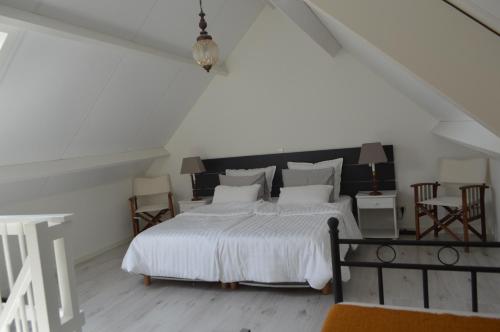迪斯胡克Huis aan Honte的白色卧室配有白色大床和椅子