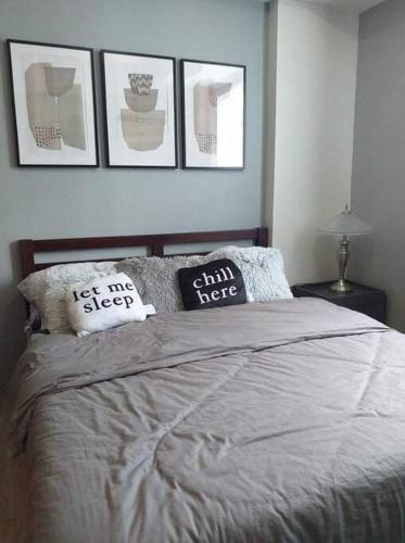 曼达维市Cozy Condominium near Mactan International Airport的卧室配有一张四幅画的墙壁床。