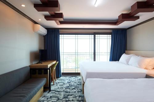 束草市Sokcho Good Morning Hotel and Resort的酒店客房,设有两张床和一张沙发