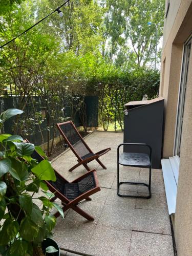 圣但尼Charme et Passion By UTA HOUSE的庭院配有椅子、桌子和椅子