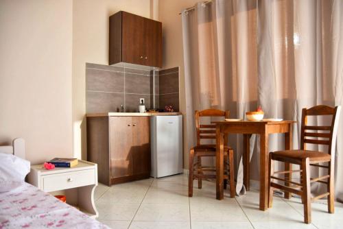 里科索翁Anemomylos Apartments的一间带桌子和冰箱的小厨房
