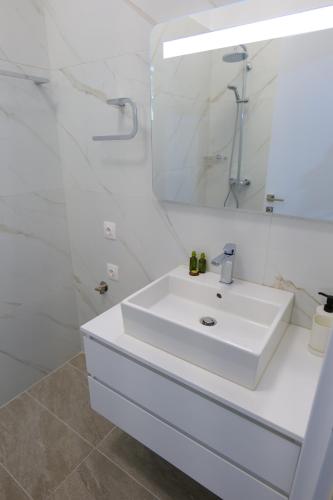 萨兰达Saranda Landscape的白色的浴室设有水槽和镜子
