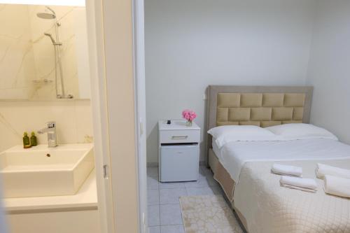 萨兰达Saranda Landscape的一间卧室配有一张床,浴室设有水槽