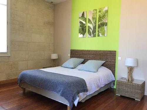 波尔多B&B La Halte Montaigne的一间卧室设有一张床和绿色的墙壁