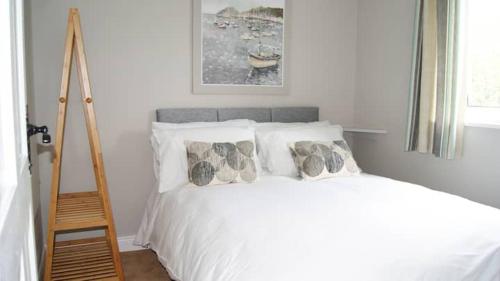 沃特福德Bubbles on the bay的卧室配有带枕头和梯子的白色床。