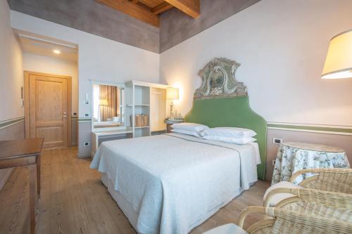 Mezzane di Sotto塔玛索蒂雷莱斯迪坎帕格纳1号酒店的一间卧室配有一张大床和绿色床头板