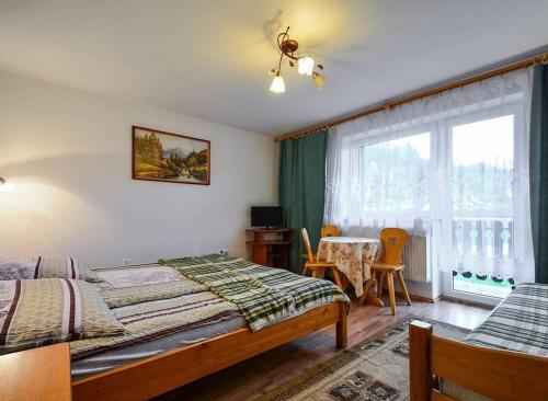 克罗奇琴科Pokoje gościnne u Bożenki的一间卧室配有一张床、一张桌子和一个窗户。