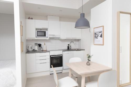 罗瓦涅米Studio Leppälä的厨房配有白色橱柜和桌椅