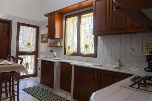 法萨诺冬妮娅别墅的厨房配有木制橱柜、水槽和窗户。