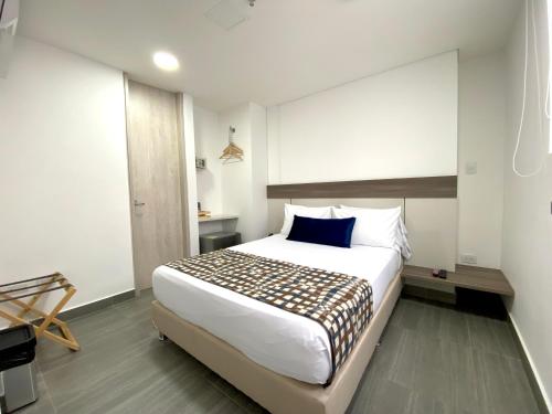 麦德林Seven Inn Hotel的卧室配有一张白色大床和蓝色枕头