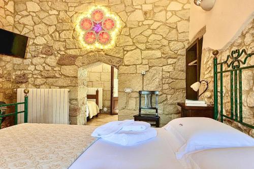 科里利亚诺多特兰托Masseria Casina Montana的一间卧室设有一张床和石墙