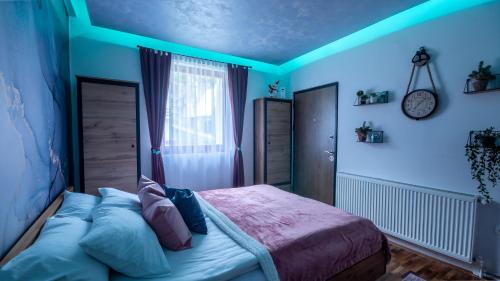 弗拉西克Alpin Apartments Vlašić的一间拥有蓝色墙壁的卧室、一张床和窗户
