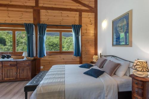 塞里特雷尼科B&B Villa Irene Plitvice Lakes的一间卧室配有一张带蓝色窗帘的大床