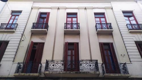 蒙得维的亚Posada Del Gaucho的白色的建筑,设有窗户和阳台