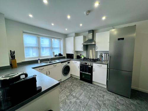 科尔切斯特North Colchester Homestay的厨房配有白色橱柜和不锈钢冰箱
