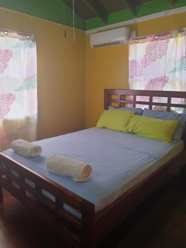 格罗斯岛Seawind Cottage- Traditional St.Lucian Style的房间里的一张床位,上面有两条毛巾