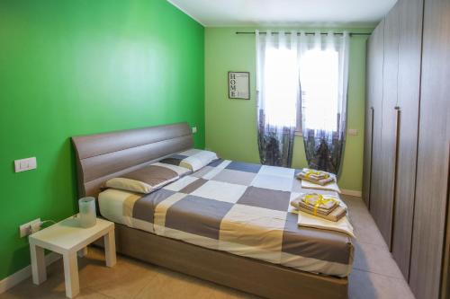 林比亚泰Maison Emozioni的绿色卧室配有床和桌子