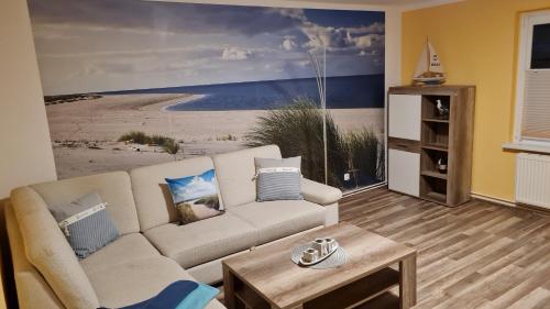 奥斯特西巴德钦诺维茨Ferienhaus Wiese und Meer的客厅配有沙发和海滩绘画