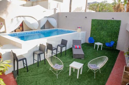 卡波圣卢卡斯Donjuan By Melida Hotel的一个带椅子的户外庭院和一个游泳池
