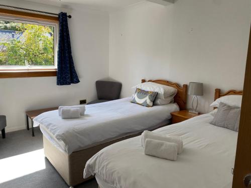 巴拉胡利什Lyn leven cottages的一间卧室设有两张床和窗户。