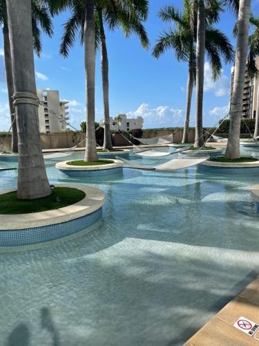 迈阿密Four Seasons Hotel Miami - Luxury Private Residences的度假村内棕榈树游泳池