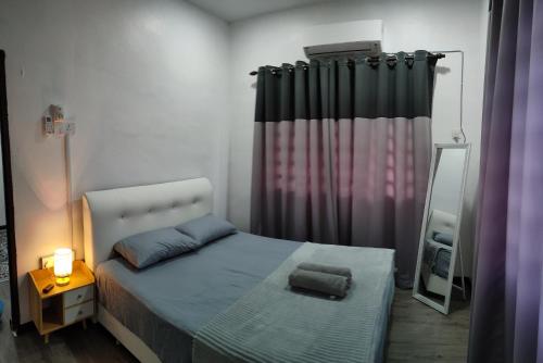 日得拉DARUL AMAN Homestay Jitra的一间小卧室,配有一张床和镜子