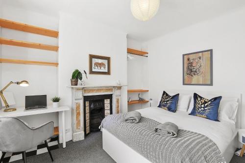 伦敦Stunning Victorian property near Canary Wharf!的一间卧室配有一张床、一张桌子和一把椅子
