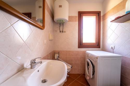 圣特奥多罗House in San Teodoro among the scents of Sardinia的一间带水槽和洗衣机的浴室