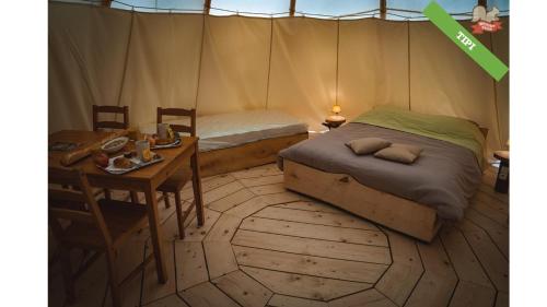 费康木香园酒店的一间卧室配有一张床,帐篷内配有一张桌子