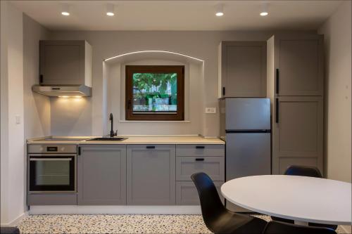 奥帕提亚Premium Apartments Villa Ula,Free Private PARKING的厨房配有桌子、冰箱和水槽