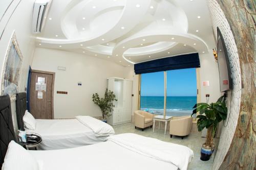 索哈尔Nhar Accommodation House的一间带两张床的卧室,享有海景
