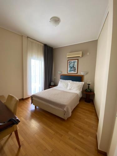 雅典亚当酒店的一间卧室设有一张大床和一个窗户。