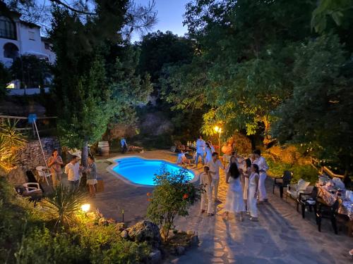隆达Casa La Muralla的一群人晚上站在游泳池周围