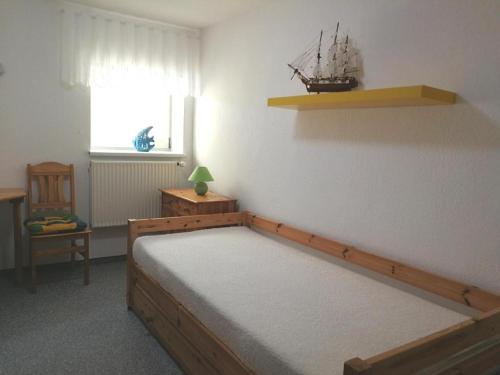 博尔滕哈根Ferienwohnung Mertins的卧室配有一张床,墙上有小船