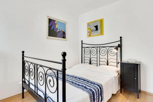 伊佐拉Vila Adriana的一间卧室配有黑色的床和白色床单