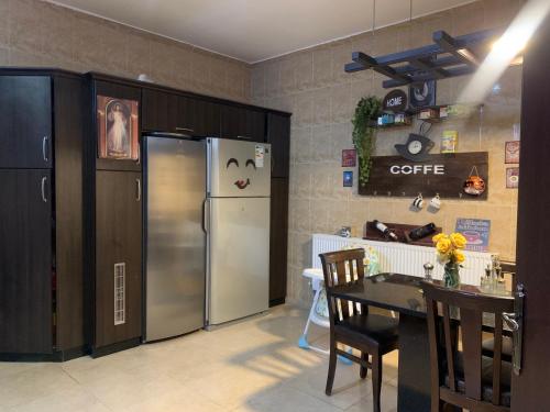 马达巴Laura’s Modern Villa的厨房配有不锈钢冰箱和桌子