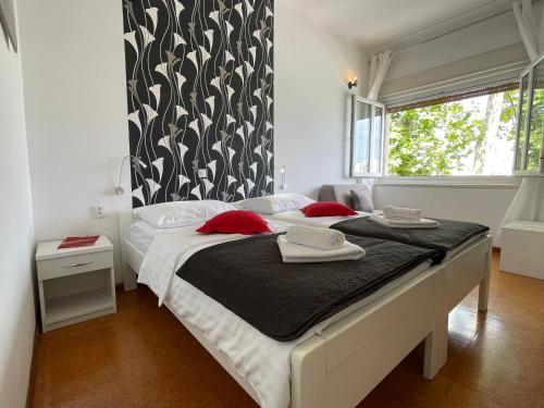 扎达尔加鲁拉旅馆的卧室配有带红色枕头的大型白色床