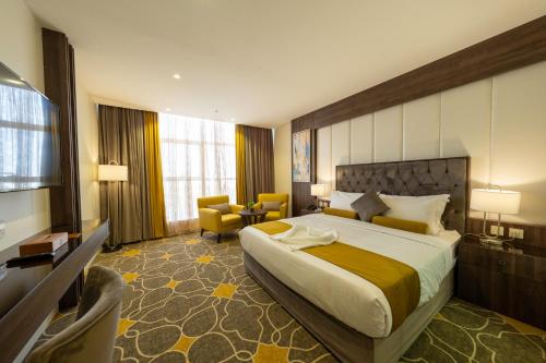 艾卜哈Abha Gardn Millennium Hotel的酒店客房带一张大床和一把椅子