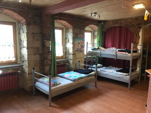 梅森Hostel Meissen Old Town Bridge的砖墙内带三张双层床的房间