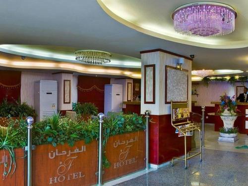 吉达Al Farhan Apartment Al Hamra-Jeddah的大堂设有植物和吊灯的酒店