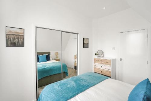 阿洛厄Myreton Hill Apartment的白色卧室配有床和镜子